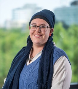 headshot of lady with a green background